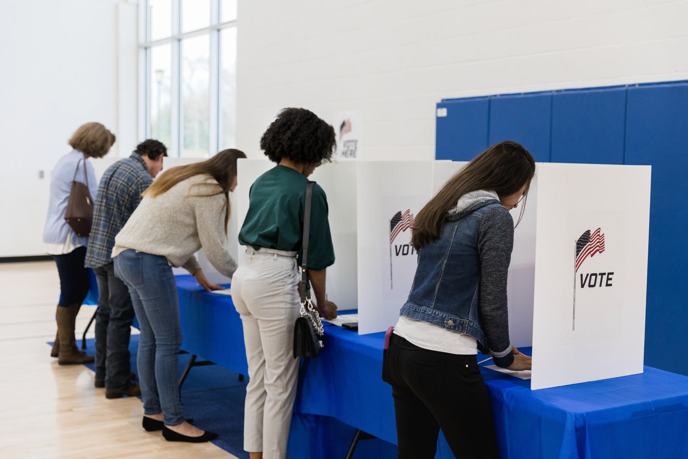 Multi-ethnic group votes at voting booths